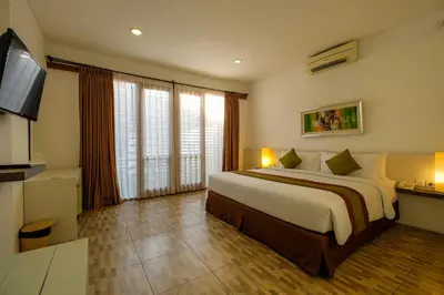 a bedroom with a large bed and a flat screen tv at Papillon Umalas Villas in Canggu