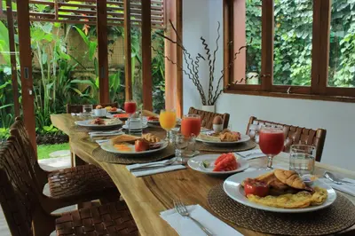 a long wooden table with plates of food on it at Papillon Umalas Villas in Canggu
