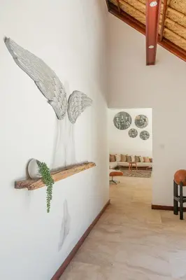 a white wall with a vase on a shelf at Balidroomvilla Sanur - Full Serviced - Beachside in Sanur