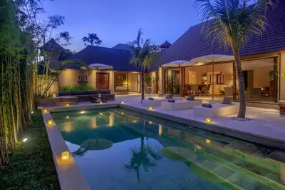 a villa with a swimming pool at night at Balidroomvilla Sanur - Full Serviced - Beachside in Sanur