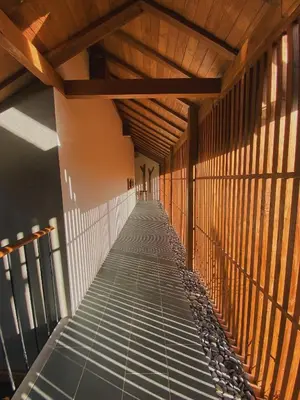 a walkway in a building with a wooden ceiling at Tekuni 2 in Legian