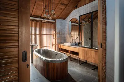 a large bathroom with a tub and a sink at Tekuni 2 in Legian
