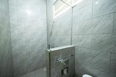 a bathroom with a shower stall with a toilet at Bendesa Accommodation in Kuta