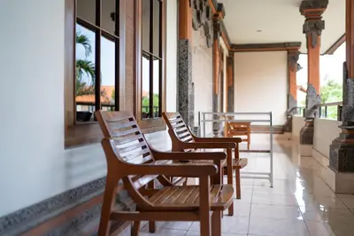 a row of chairs sitting in a room with windows at Bendesa Accommodation in Kuta