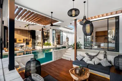 an open living room with a pool and a house at Villa Australis in Kerobokan