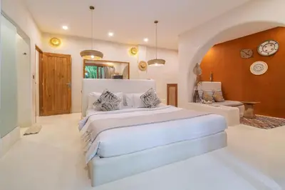 a bedroom with a large white bed in a room at White Goose Boutique Hotel in Canggu