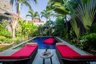 a backyard with a pool with red tables and chairs at CASA PINARAK 1 I 3BR Private Villa near Seminyak in Seminyak