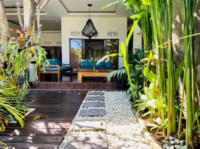 a tropical garden with a living room with blue furniture at CASA PINARAK 1 I 3BR Private Villa near Seminyak in Seminyak