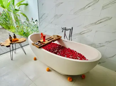 a bath tub filled with red berries in a bathroom at Alami Luxury Villa in Seminyak