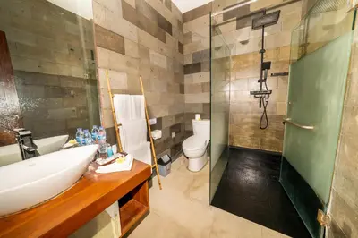 a bathroom with a sink and a shower and a toilet at Bali Karma Sajtra Hotel in Seminyak
