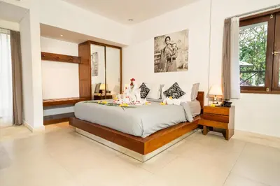 a bedroom with a large bed and a window at Bali Karma Sajtra Hotel in Seminyak