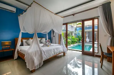 a bedroom with a canopy bed and a pool at VILLA SCARLET in Seminyak