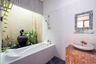a bathroom with a bath tub and a sink at VILLA SCARLET in Seminyak
