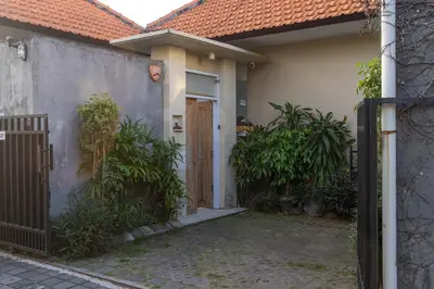 a house with a wooden door and some plants at VILLA SCARLET in Seminyak