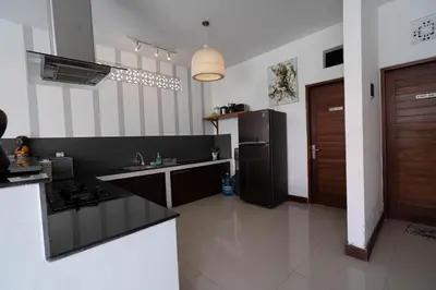 a kitchen with a black refrigerator and a sink at VILLA SCARLET in Seminyak