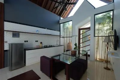 a kitchen with a glass table and purple chairs at PANDAWA VILLAS SEMINYAK in Seminyak