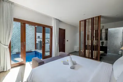 a bedroom with a white bed and a pool at PANDAWA VILLAS SEMINYAK in Seminyak