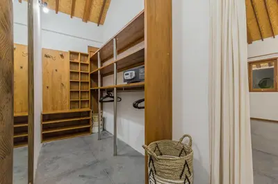 a walk in closet with wooden shelves and a basket at Villa B in Seminyak
