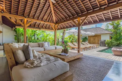 an outdoor living room with a couch and a table at Villa B in Seminyak