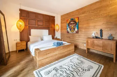 a bedroom with a bed and a painting on the wall at Villa Hatari Canggu in Kerobokan