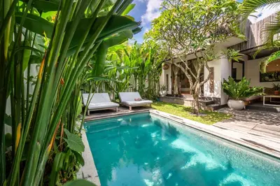 a pool in the backyard of a house with plants at Villa Hatari Canggu in Kerobokan