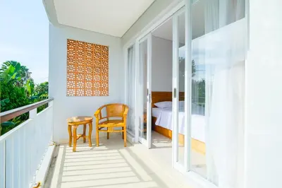 a bedroom with a bed and a table and chairs at Dharma Guest House Seminyak RedPartner in Seminyak