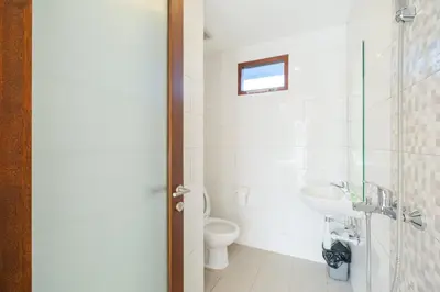 a bathroom with a toilet and a sink at Dharma Guest House Seminyak RedPartner in Seminyak