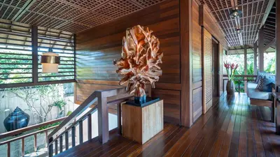 a lobby with a wooden wall with a sculpture at Villa Windu Sari in Seminyak