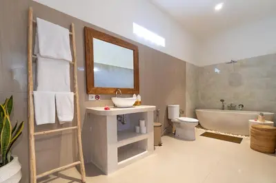 a bathroom with a sink and a tub and a toilet at CASTELU 3BR peacefully villa near Mertanadi in Seminyak