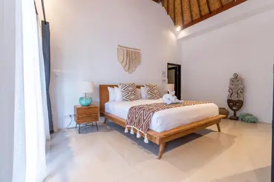a bedroom with a bed and a nightstand and a bed sidx sidx sidx sidx at CASTELU 3BR peacefully villa near Mertanadi in Seminyak