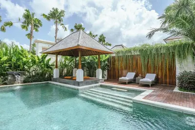 a swimming pool with a gazebo next to a house at Villa Reillo Canggu in Canggu