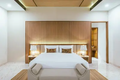 a bedroom with a large white bed and two lamps at Villa Reillo Canggu in Canggu