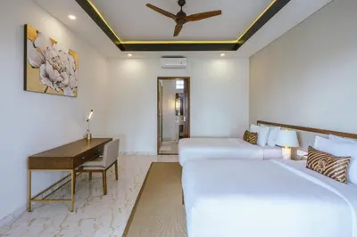 a hotel room with two beds and a desk at Villa Reillo Canggu in Canggu