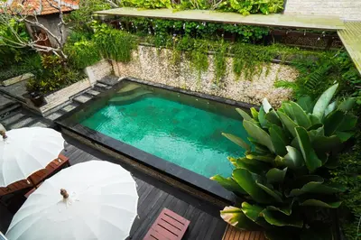 an overhead view of a swimming pool with umbrellas at Giri Bhagawan Villas & Spa in Nusa Dua