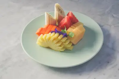 a plate of fruit on a white plate at Giri Bhagawan Villas & Spa in Nusa Dua