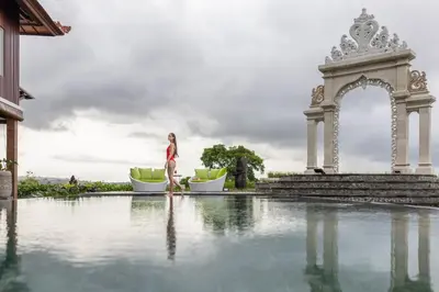 a woman walking by a pool at a resort at Giri Bhagawan Villas & Spa in Nusa Dua