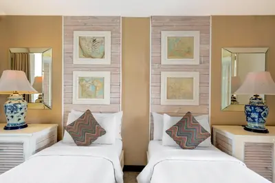 two beds in a room with two mirrors at The Kanjeng Suites Petitenget in Seminyak