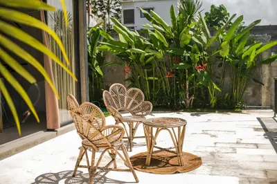 a group of chairs and tables on a patio at Villa Kamal Umalas in Kerobokan