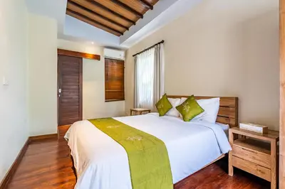 a bedroom with a white bed and a window at Anedda Merta Sari Villa Sanur in Sanur