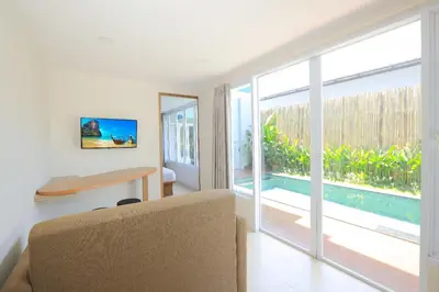 a living room with a table and a sliding glass door at Lacrissa Bali in Kerobokan