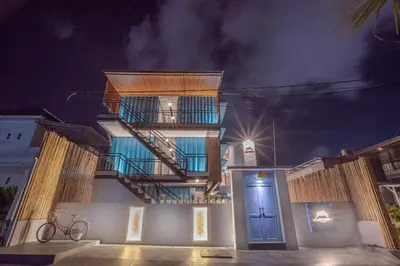 a building with a staircase and a blue door at night at Lacrissa Bali in Kerobokan
