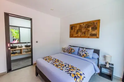 a bedroom with a bed and a mirror at Villa Lys by Alfred in Bali in Canggu