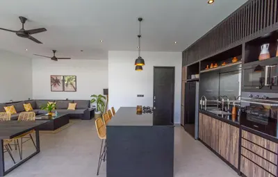 a kitchen and a living room with a couch at Villa Lys by Alfred in Bali in Canggu