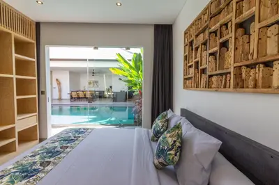 a bedroom with a bed and a swimming pool at Villa Lys by Alfred in Bali in Canggu