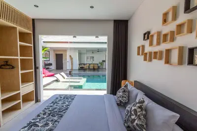 a bedroom with a bed and a swimming pool at Villa Lys by Alfred in Bali in Canggu