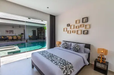 a bedroom with a large bed and a swimming pool at Villa Lys by Alfred in Bali in Canggu
