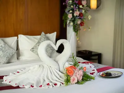 two white swans are sitting on a bed at Samaja Villas Seminyak in Seminyak
