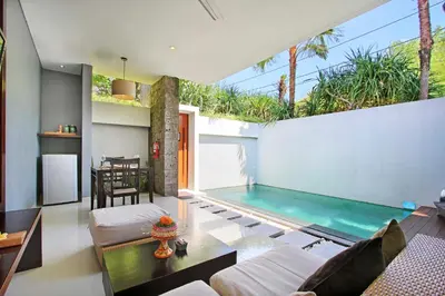an indoor swimming pool in a house with a living room at Samaja Villas Seminyak in Seminyak