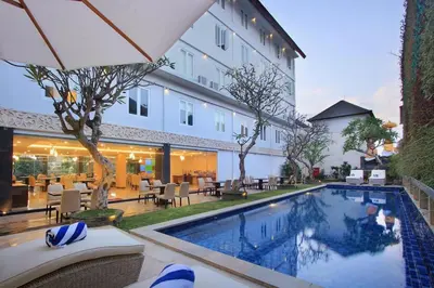 a hotel with a swimming pool in front of a building at Mars City Hotel in Denpasar