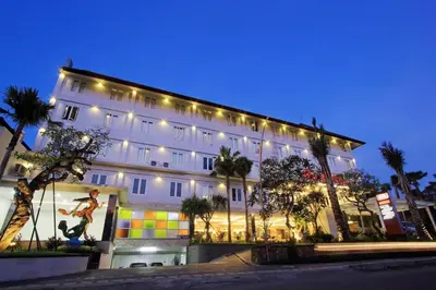 a large building with a man on a skateboard in front of it at Mars City Hotel in Denpasar